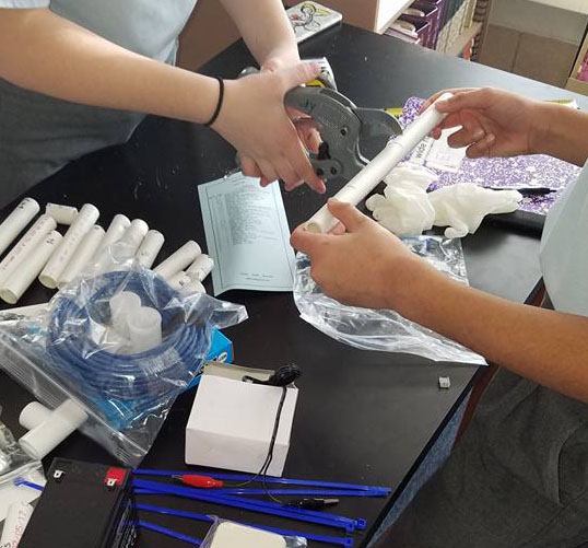 students cutting pvc pipe